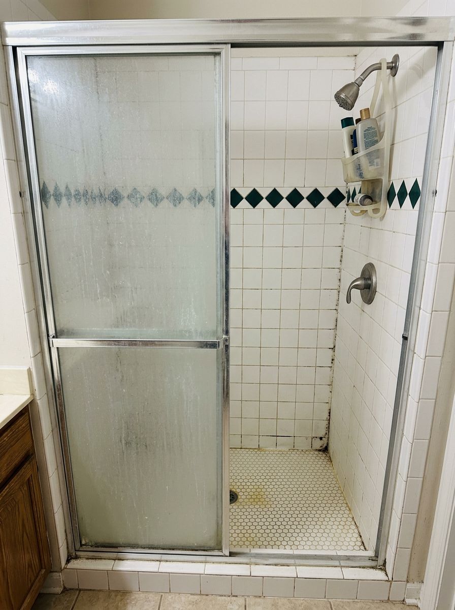 Before: dated shower with moldy grout and hard water stains